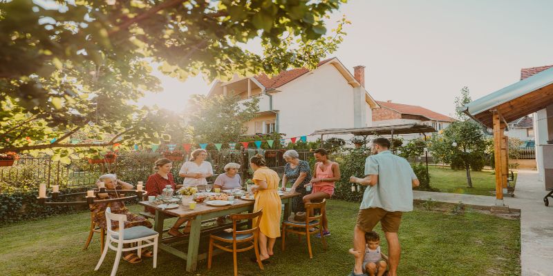 Una familia disfrutando de una comida al aire libre en un jardín.