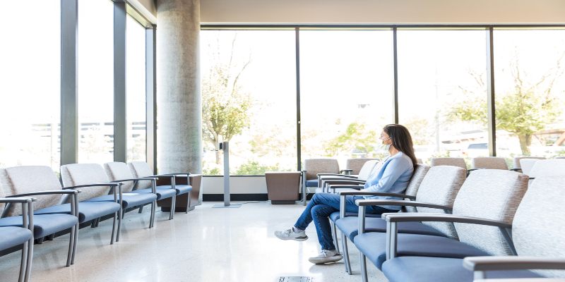 Mujer sentada en la sala de espera de un hospital.